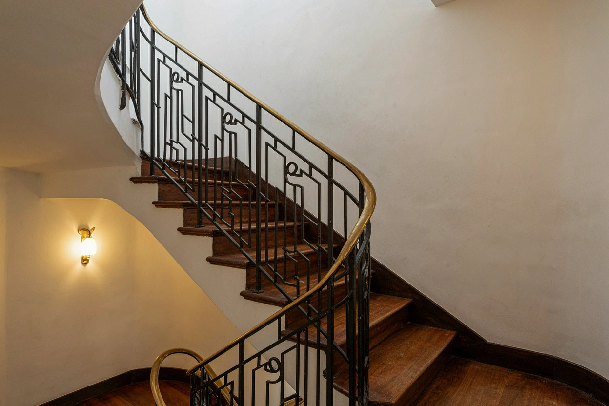 Escalier Art Déco de 1930, rampe en fer forgé géométrique et bois ciré